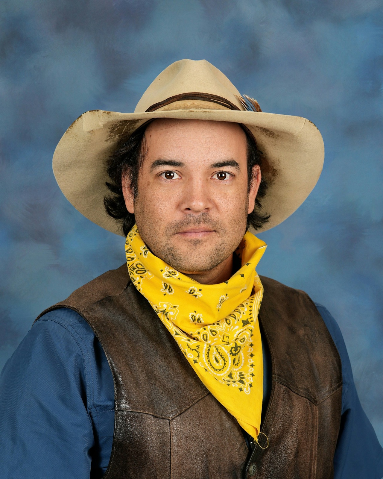 Man with hat, yellow scarf and brown vest 